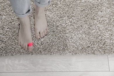 Image of Woman with joint inflammation indoors, closeup. Toned in black-and-white with color area on toe