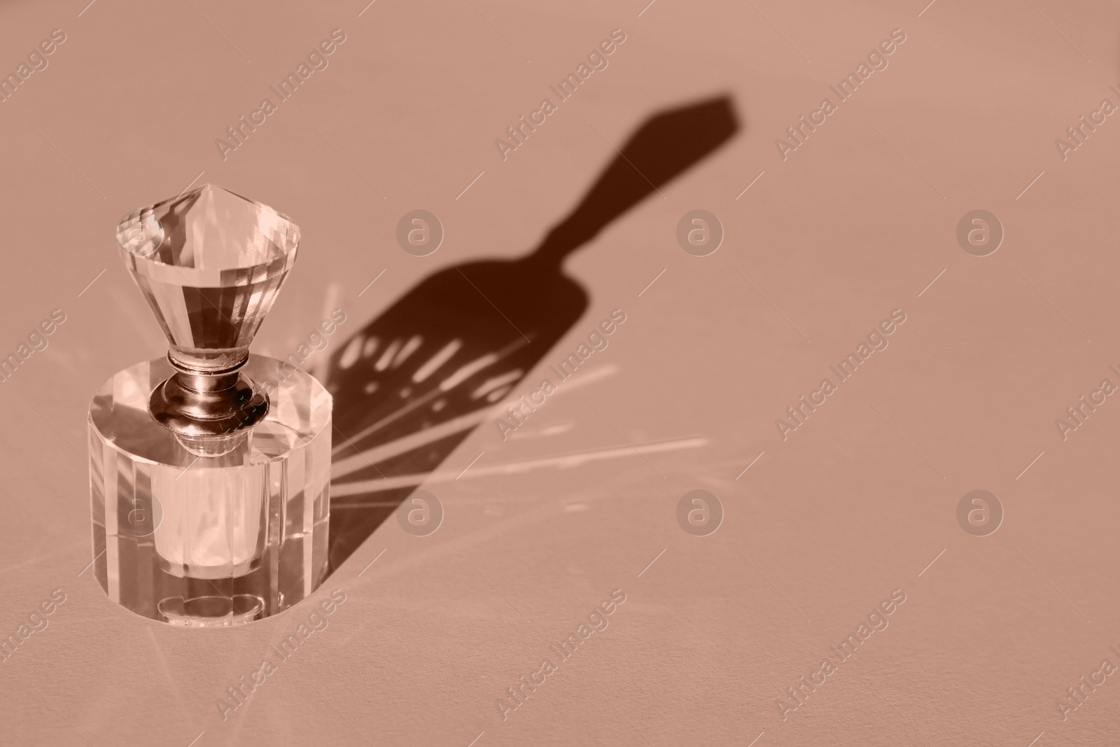 Image of Bottle of perfume on color background, toned in mocha mousse shade. Color of 2025 year