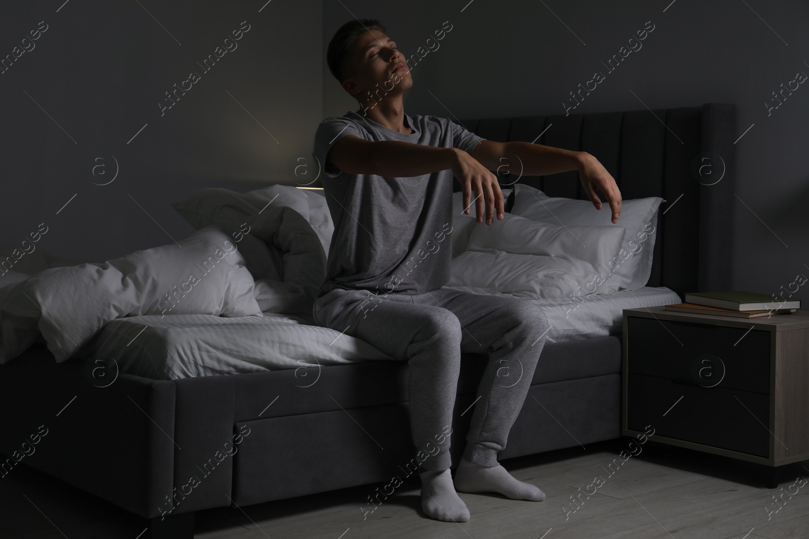 Photo of Young man suffering from sleepwalking on bed at home