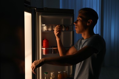 Photo of Young man suffering from sleepwalking near fridge at home