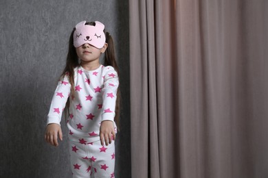 Photo of Little girl suffering from sleepwalking at home, space for text