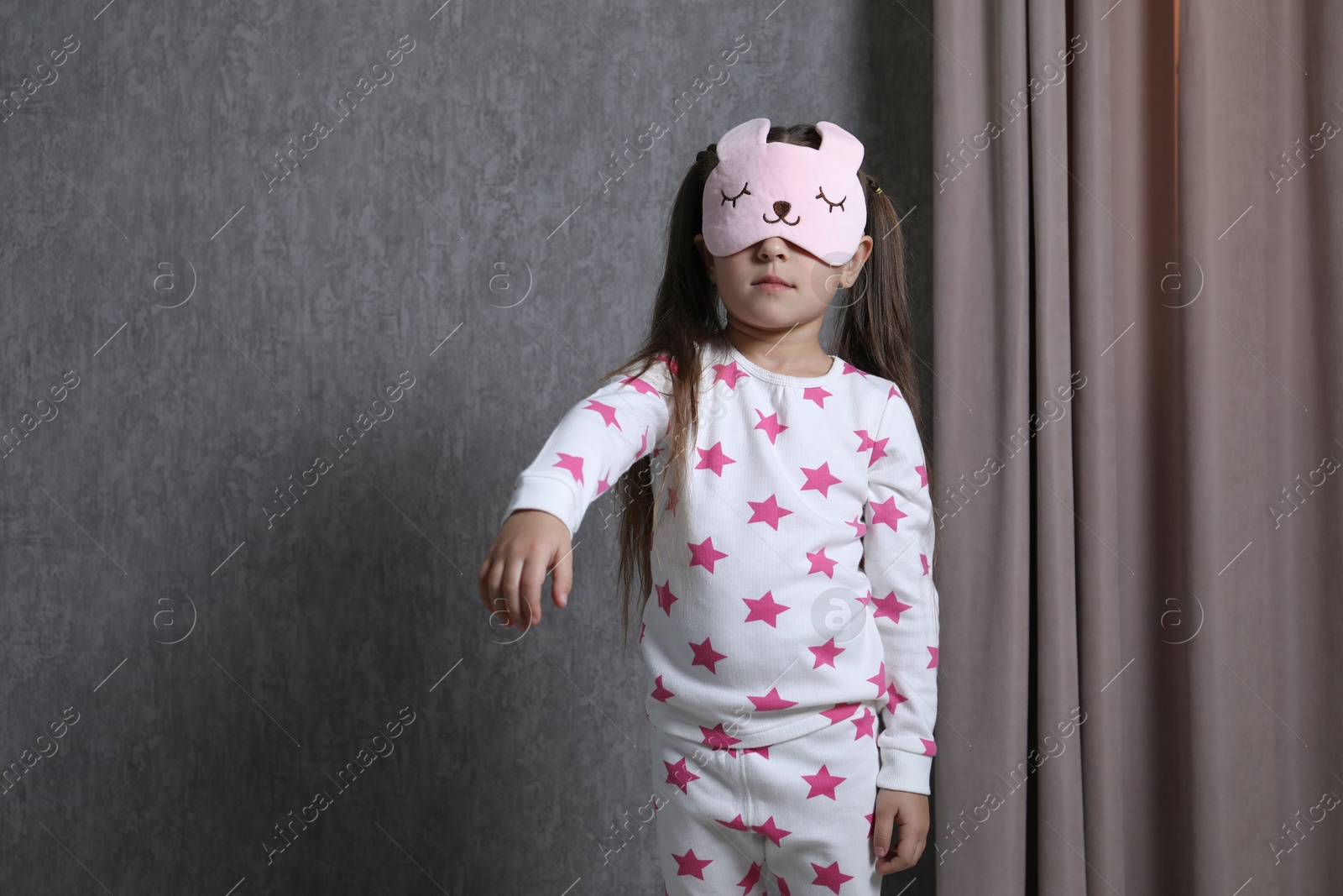 Photo of Little girl suffering from sleepwalking at home, space for text