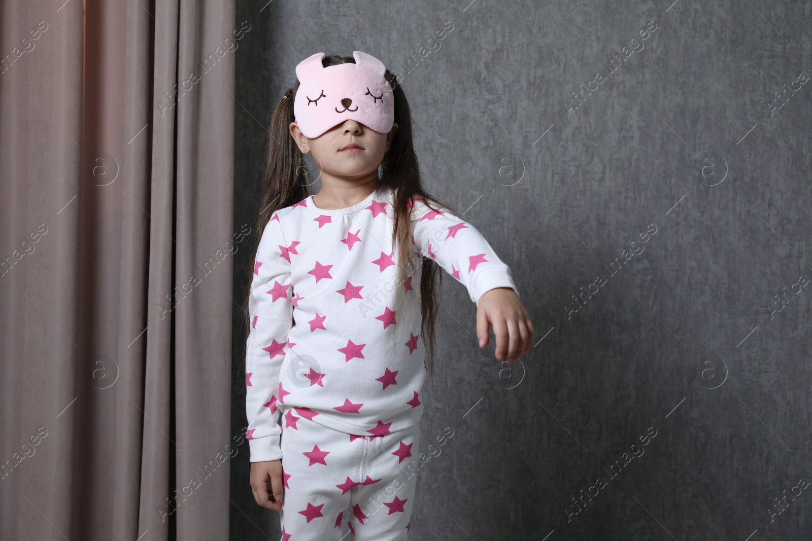 Photo of Little girl suffering from sleepwalking at home, space for text