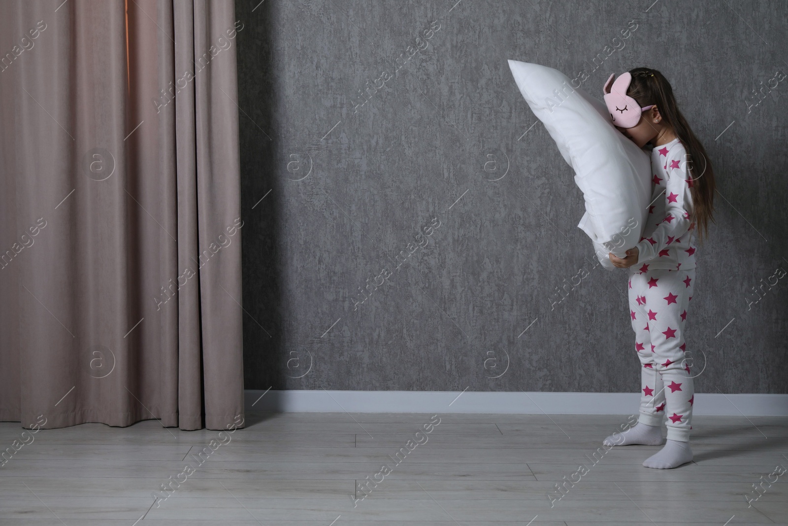 Photo of Little girl with pillow suffering from sleepwalking at home, space for text