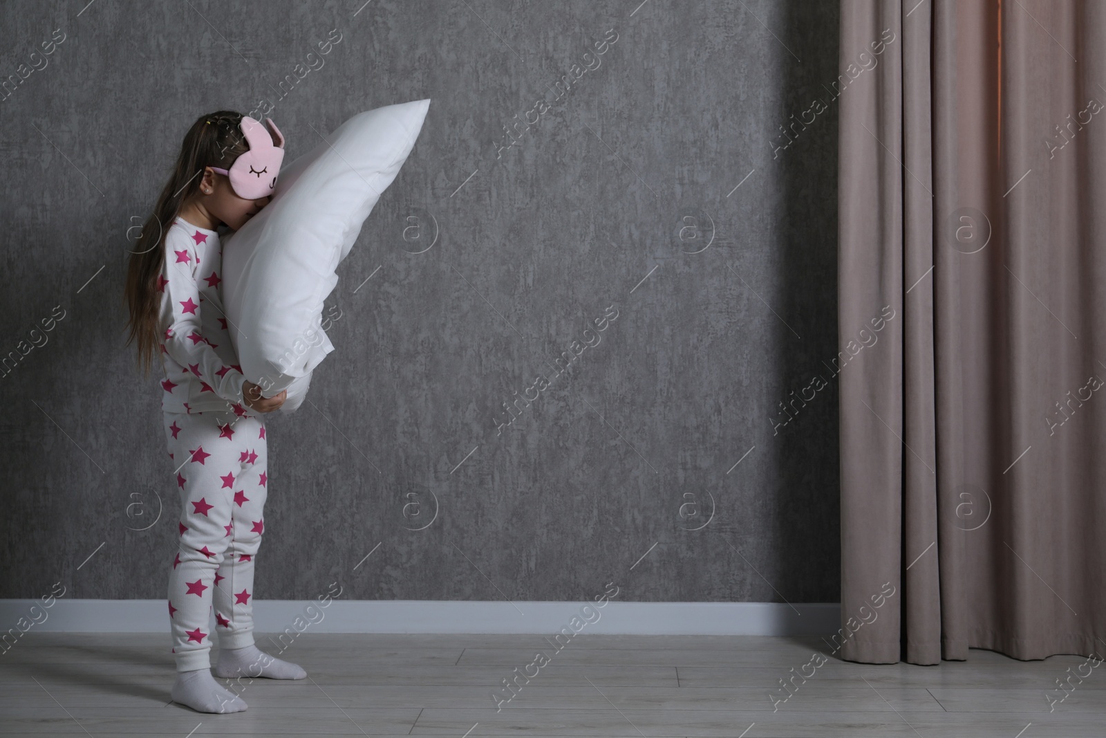 Photo of Little girl with pillow suffering from sleepwalking at home, space for text