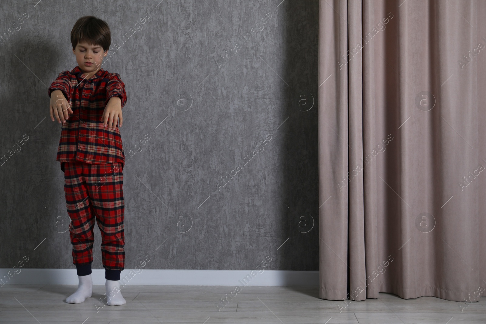 Photo of Little boy suffering from sleepwalking at home, space for text