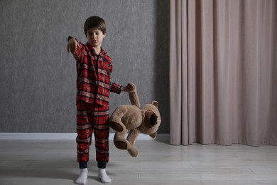 Photo of Little boy with toy bear suffering from sleepwalking at home