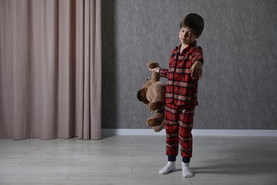 Photo of Little boy with toy bear suffering from sleepwalking at home