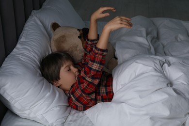 Photo of Little boy suffering from sleepwalking in bed at home