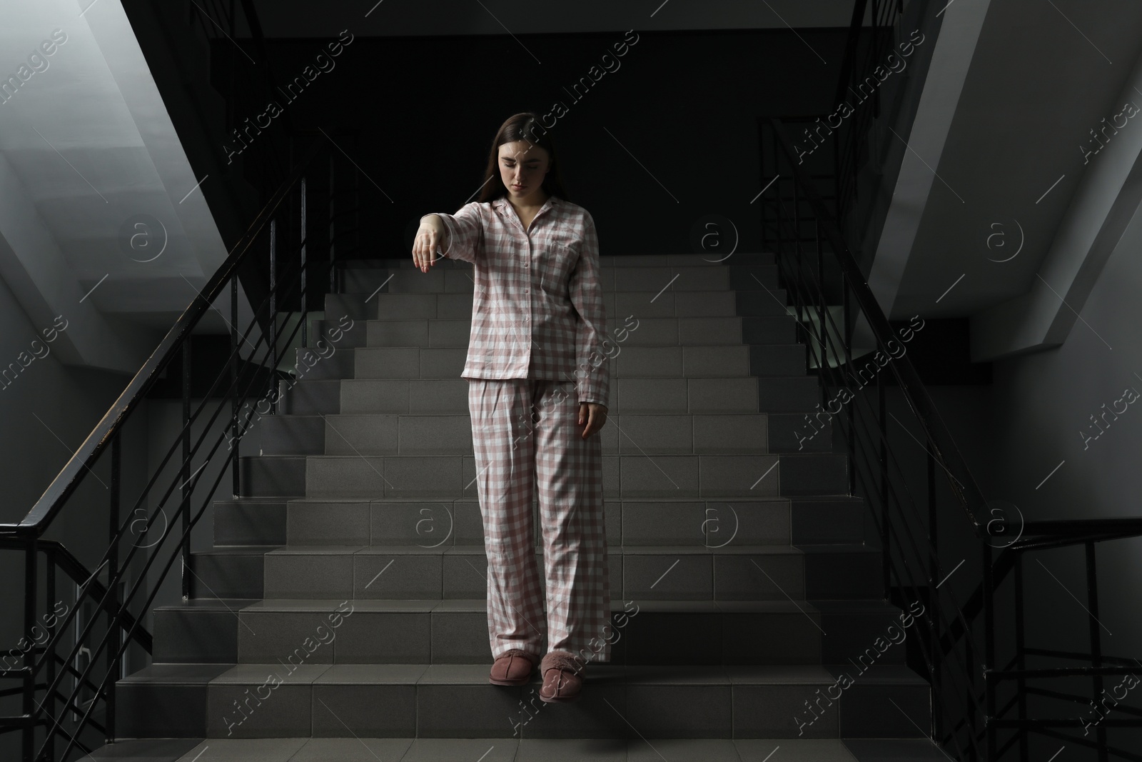 Photo of Woman suffering from sleepwalking on stairs indoors