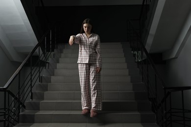 Photo of Woman suffering from sleepwalking on stairs indoors