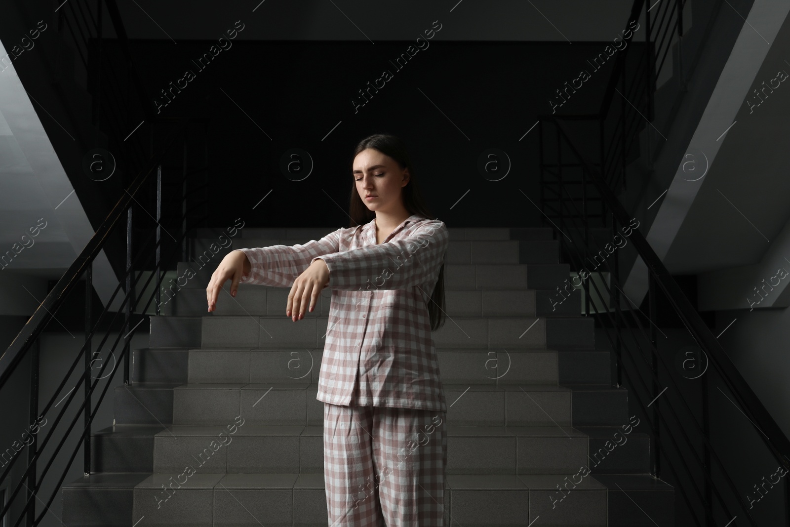 Photo of Woman suffering from sleepwalking on stairs indoors