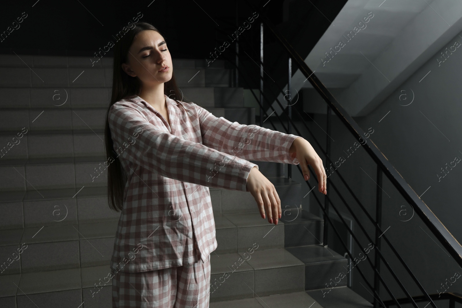 Photo of Woman suffering from sleepwalking on stairs indoors