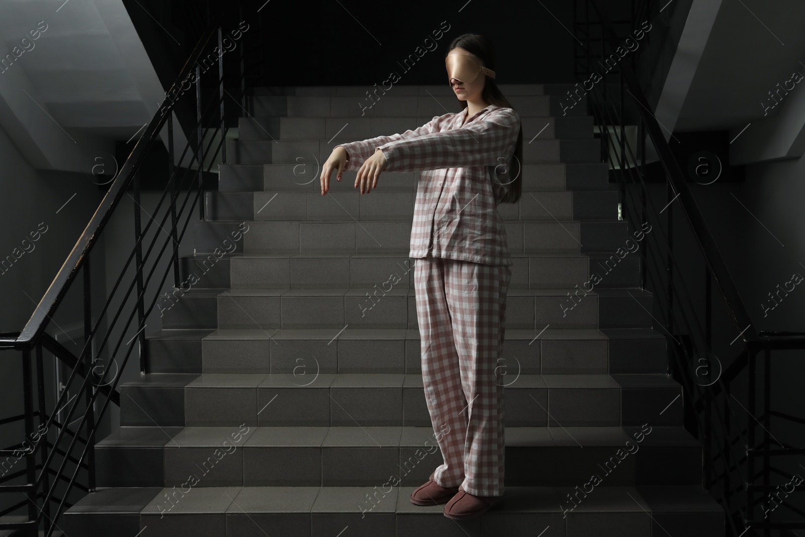 Photo of Woman suffering from sleepwalking on stairs indoors