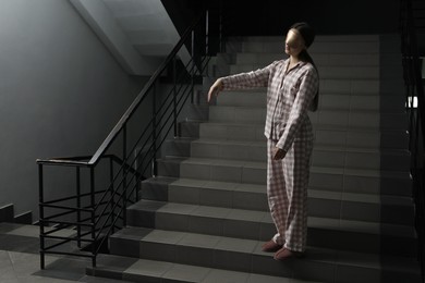 Photo of Woman suffering from sleepwalking on stairs indoors