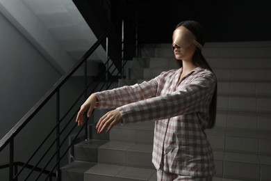 Photo of Woman suffering from sleepwalking on stairs indoors