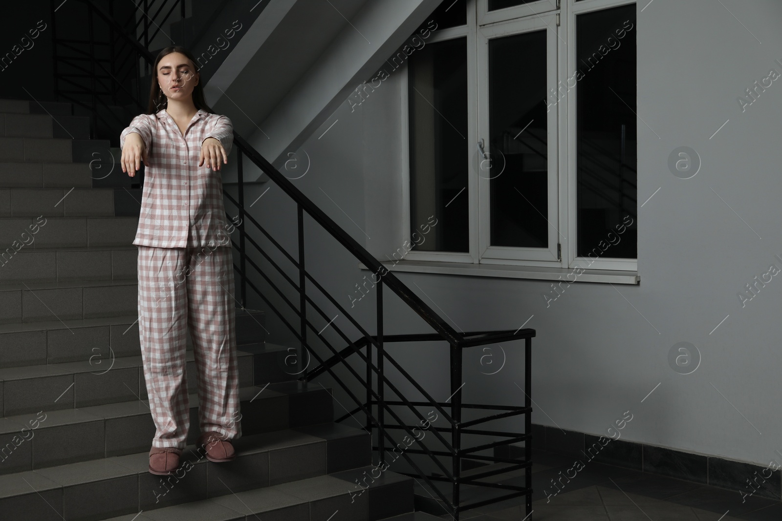 Photo of Woman suffering from sleepwalking on stairs indoors