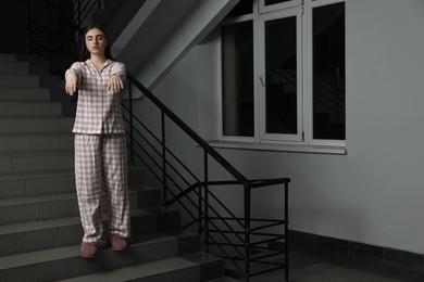 Photo of Woman suffering from sleepwalking on stairs indoors