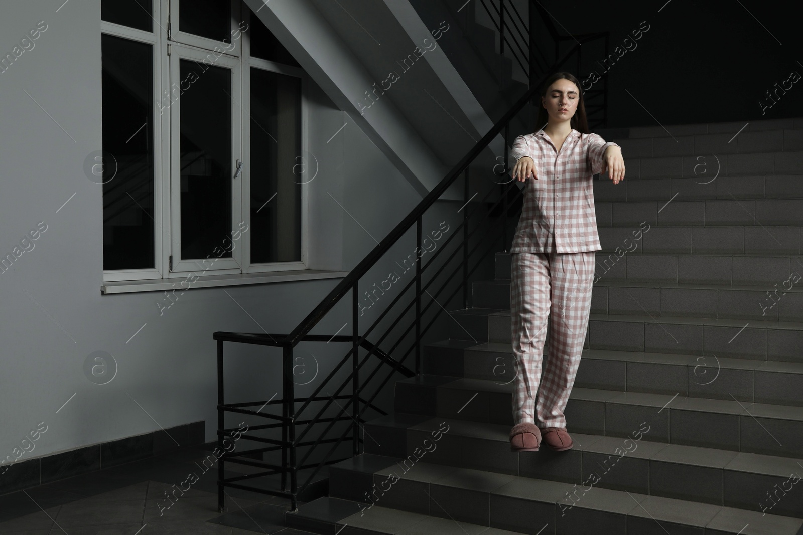 Photo of Woman suffering from sleepwalking on stairs indoors