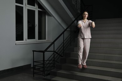 Photo of Woman suffering from sleepwalking on stairs indoors