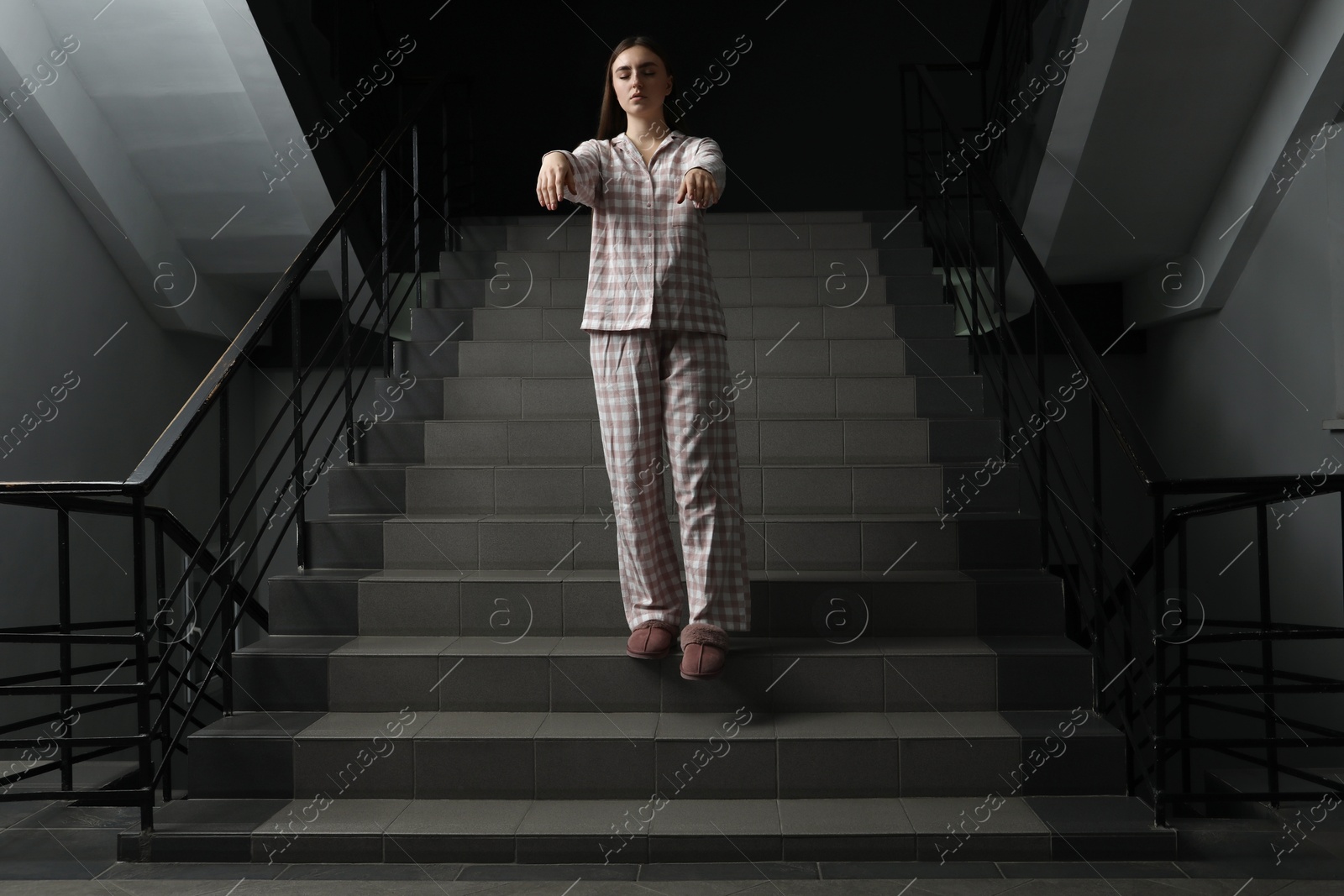 Photo of Woman suffering from sleepwalking on stairs indoors