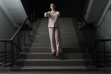 Photo of Woman suffering from sleepwalking on stairs indoors