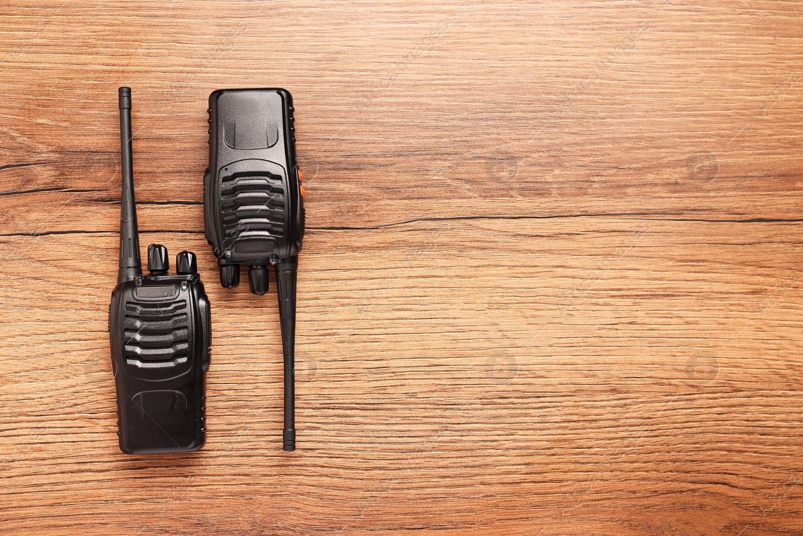 Photo of Walkie talkies on wooden table, top view. Space for text