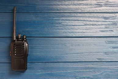 Photo of One walkie talkie on blue wooden table, top view. Space for text