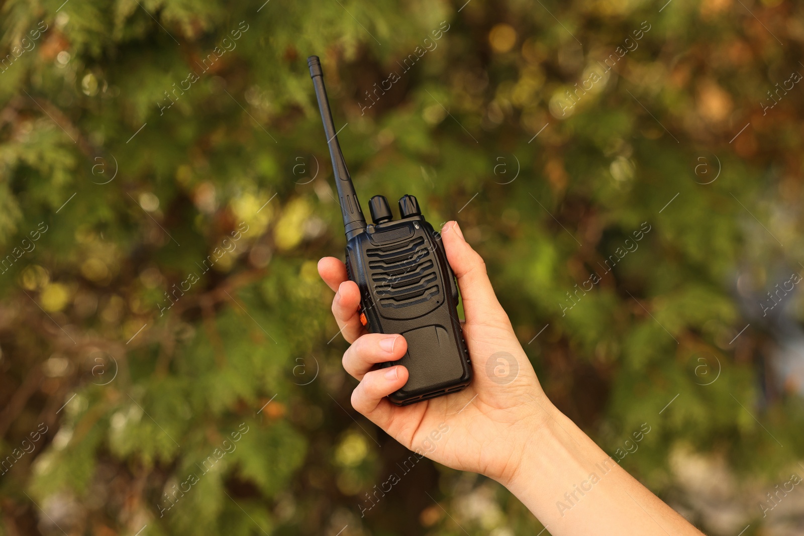 Photo of Woman with walkie talkie in park, closeup