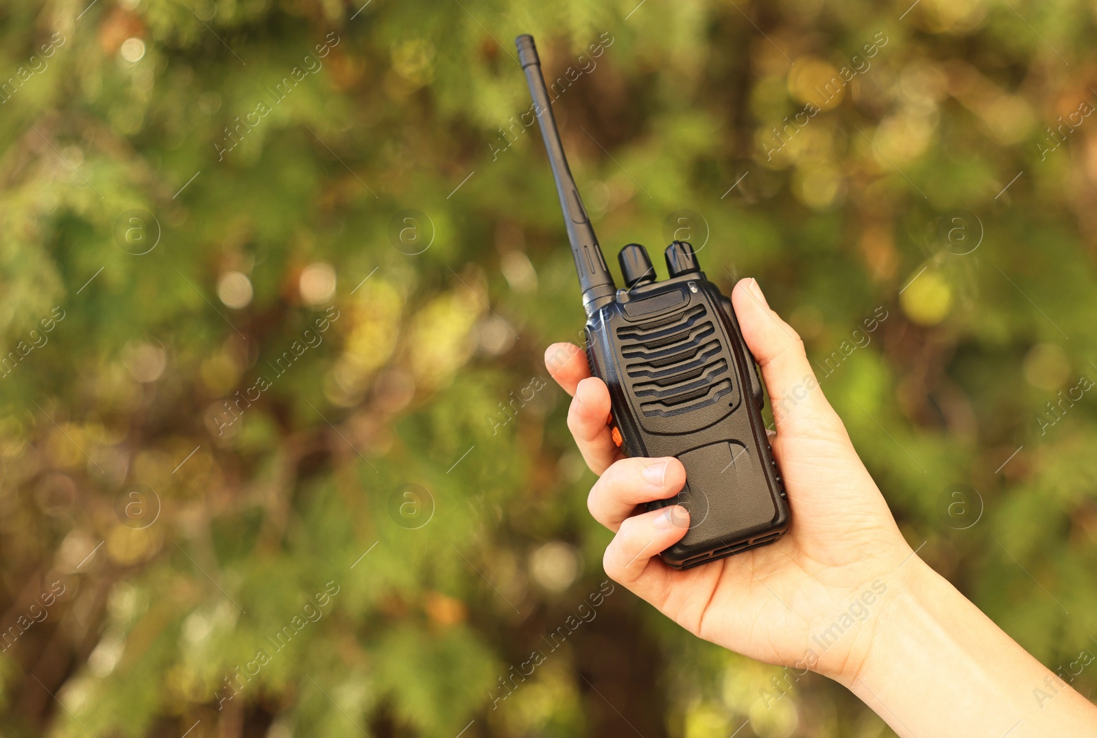 Photo of Woman with walkie talkie in park, closeup. Space for text