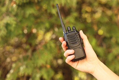 Photo of Woman with walkie talkie in park, closeup. Space for text