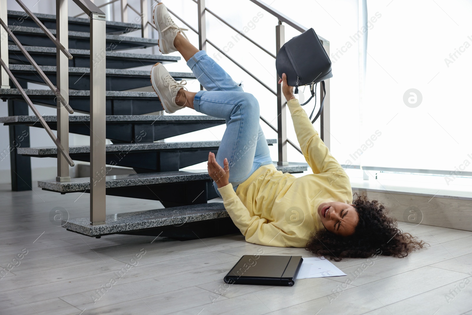 Photo of Woman falling on stairs in building. Dangerous accident