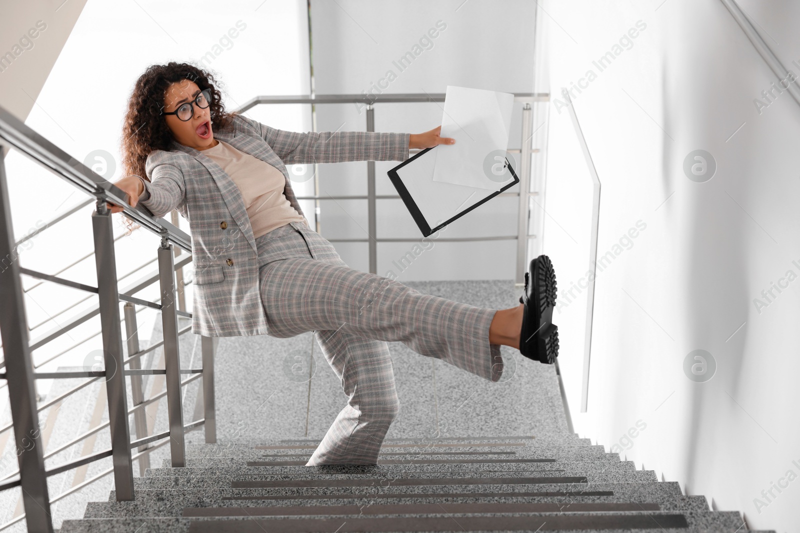 Photo of Woman falling on stairs in building. Dangerous accident