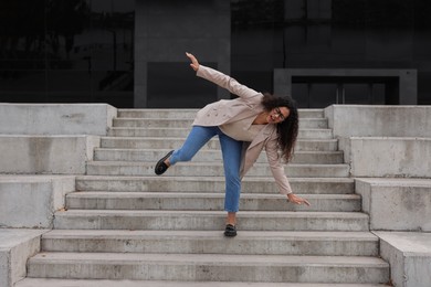 Photo of Woman falling on stairs outdoors. Dangerous accident