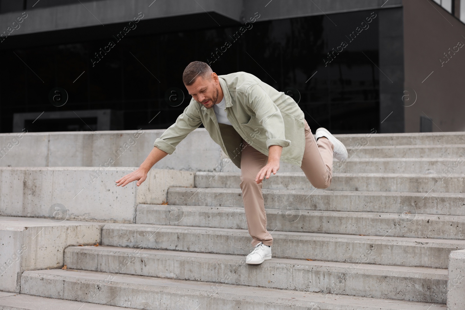 Photo of Man falling on stairs outdoors. Dangerous accident