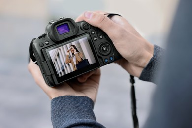 Photo of Professional photographer with modern camera outdoors, closeup