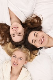 Photo of Spa day. Happy women lying on bed, above view