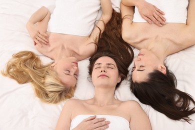 Photo of Spa day. Happy women lying on bed, above view