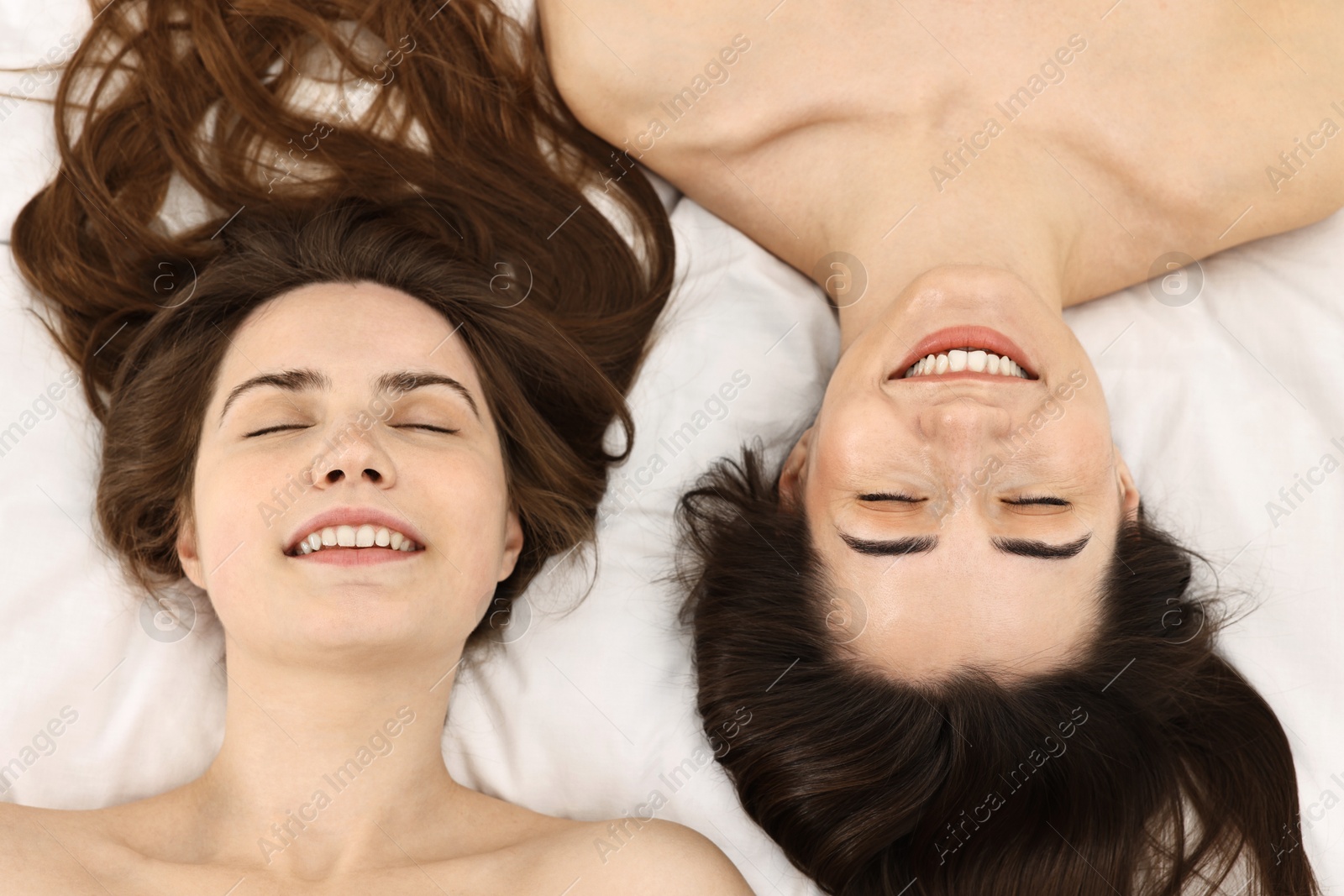 Photo of Spa day. Happy women lying on bed, above view