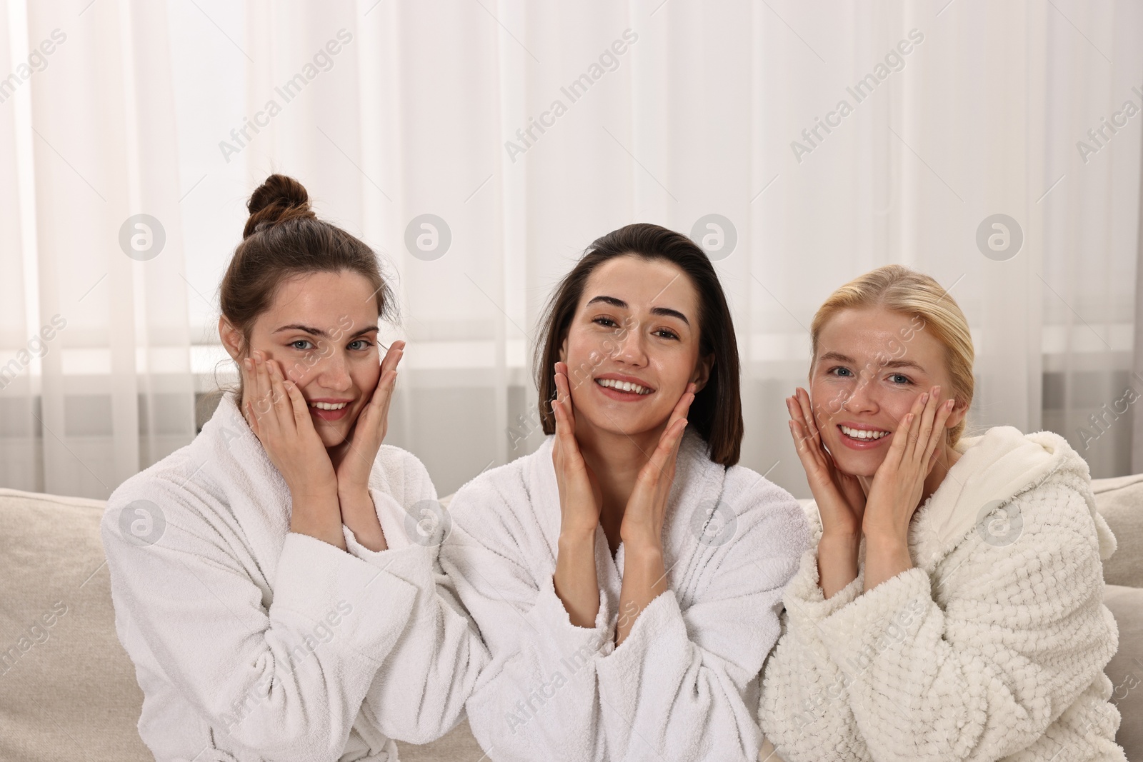 Photo of Happy woman wearing bathrobes on sofa in spa