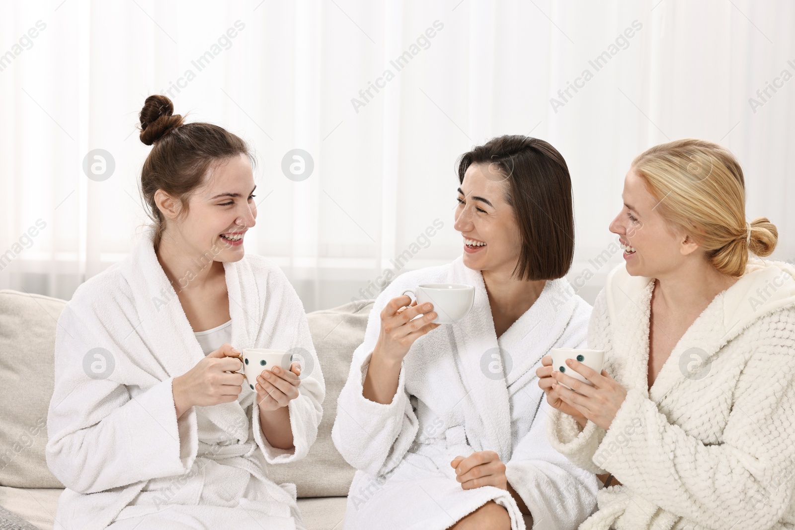 Photo of Beautiful women having tea on sofa in spa