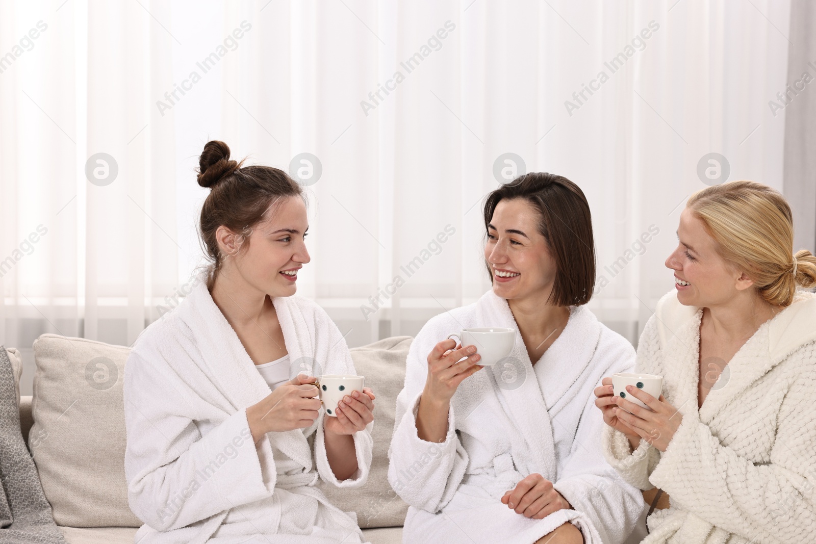 Photo of Beautiful women having tea on sofa in spa