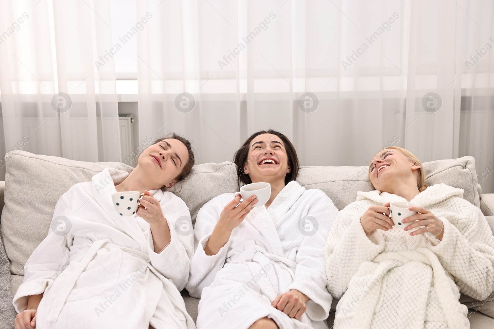 Photo of Beautiful women with tea resting on sofa in spa