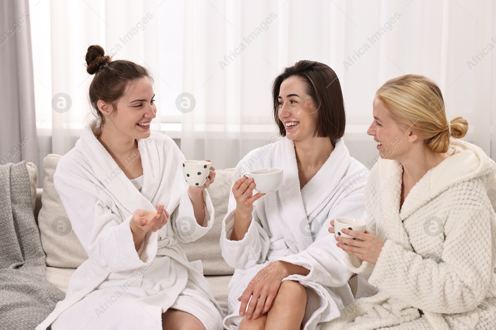 Photo of Beautiful women having tea on sofa in spa