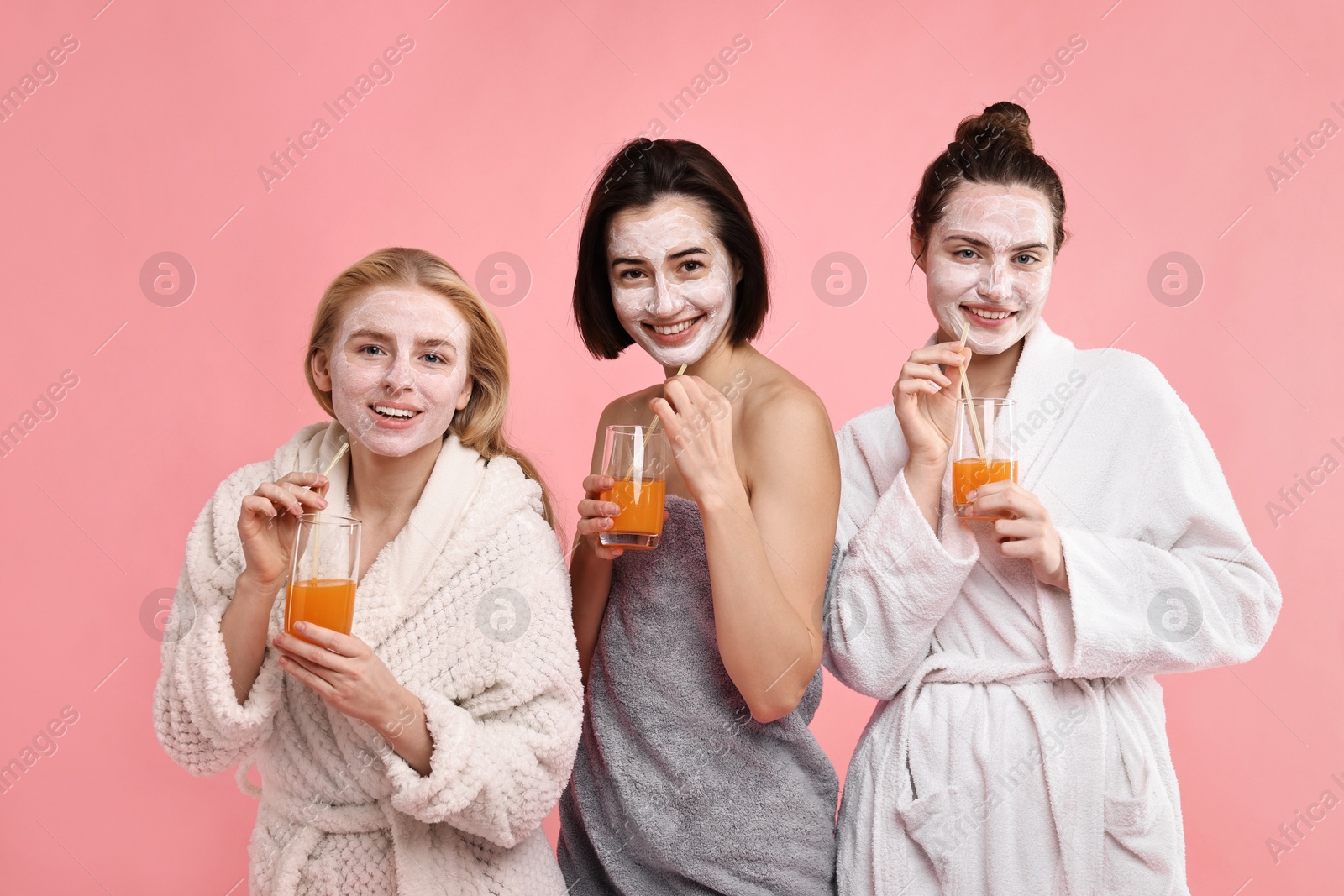 Photo of Spa day. Beautiful women with face masks and healthy drinks on pink background