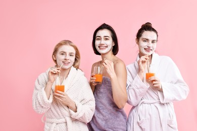 Photo of Spa day. Beautiful women with face masks and healthy drinks on pink background