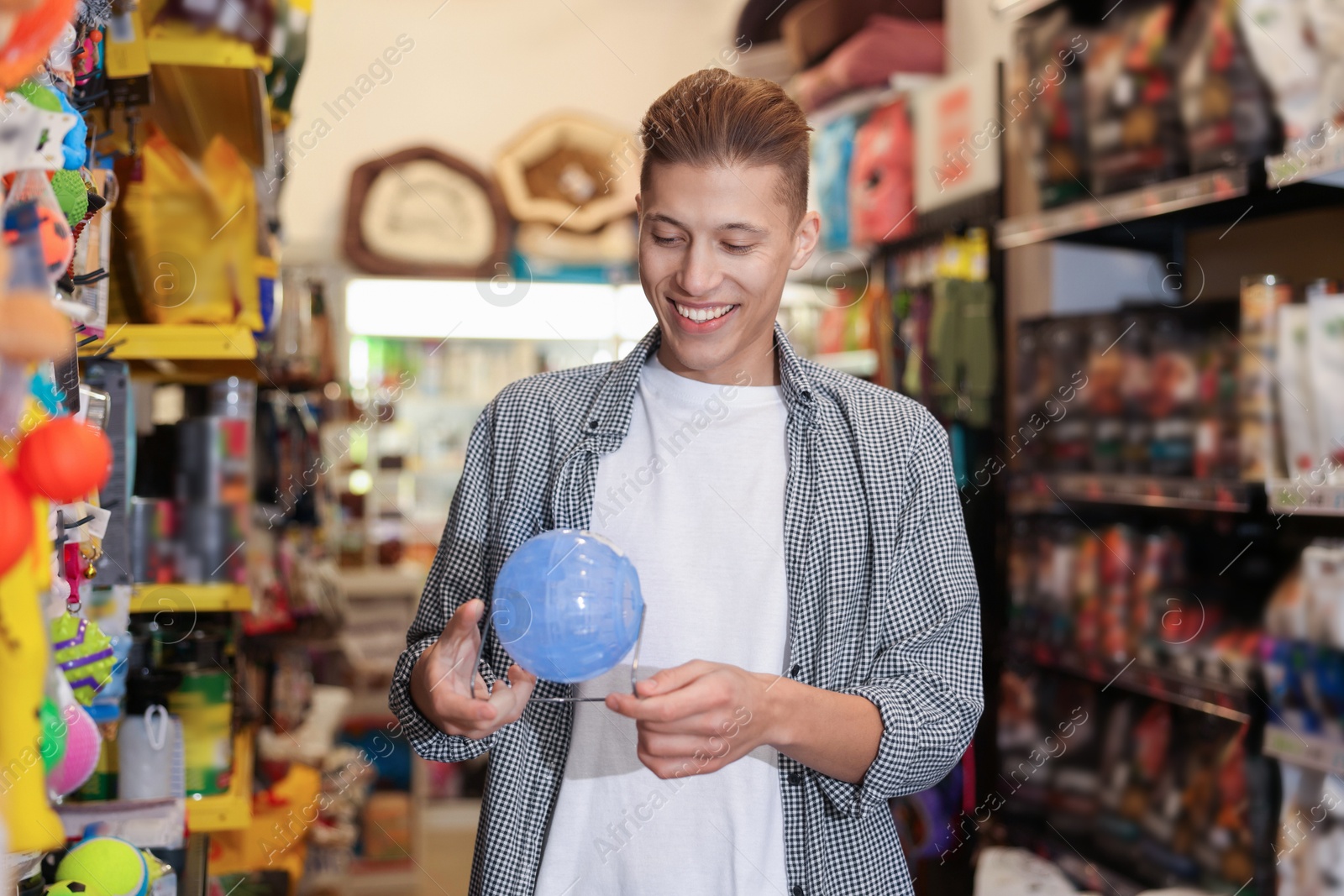 Photo of Happy man with hamster wheel in pet shop