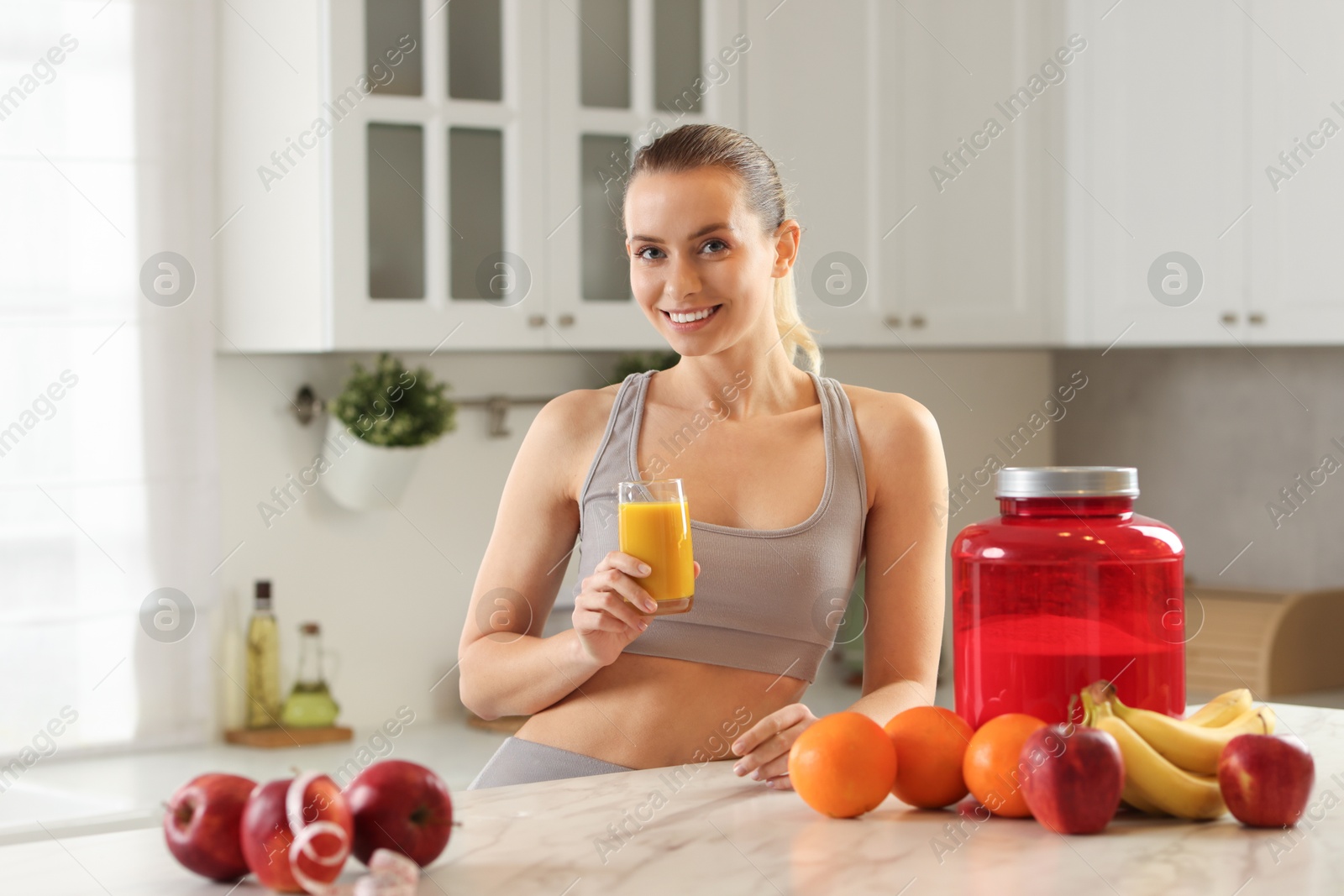 Photo of Weight loss. Happy woman with tasty shake at white marble table in kitchen