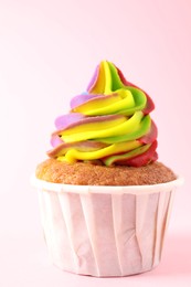 One delicious cupcake with colorful cream on pink background, closeup