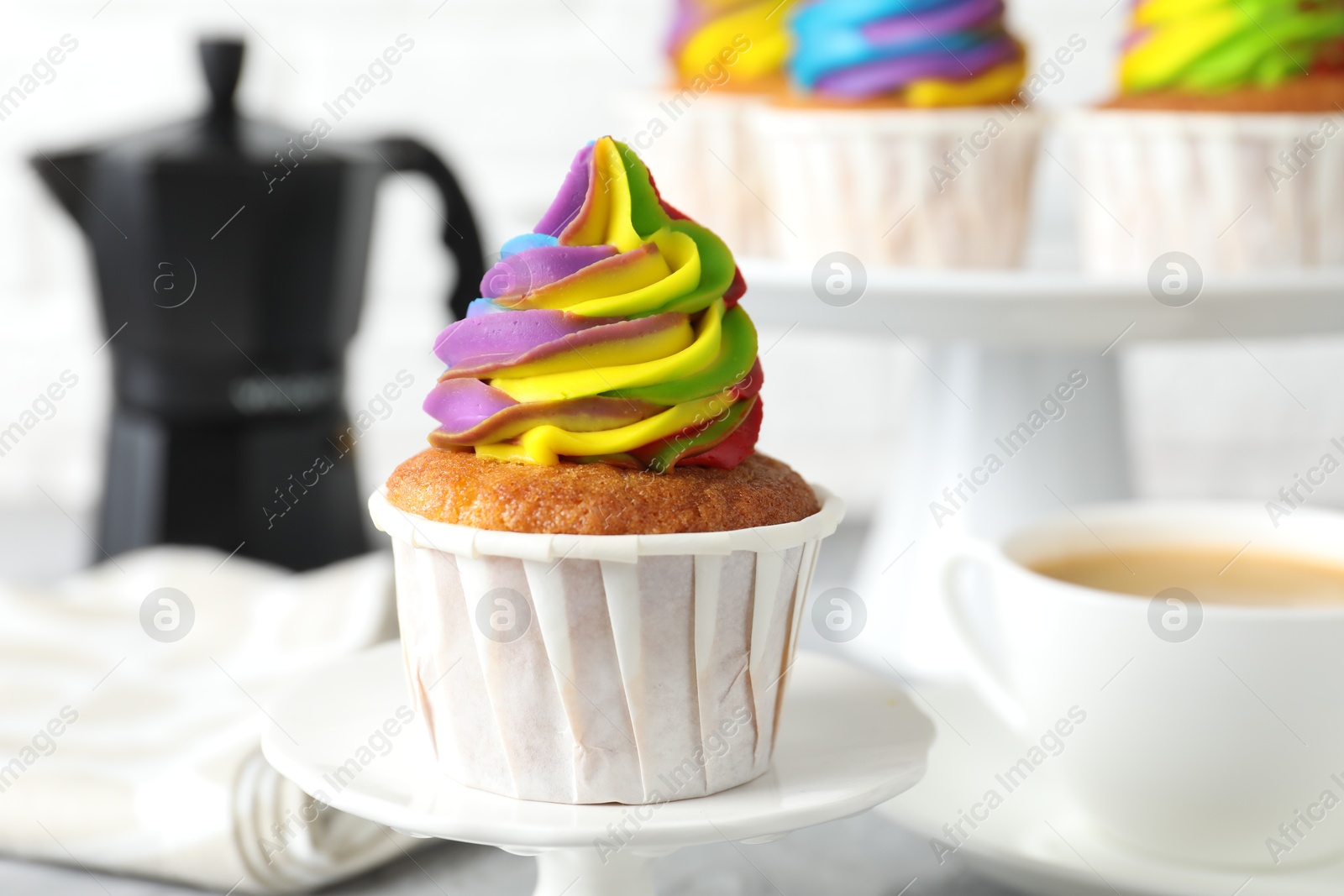 Photo of Delicious cupcake with colorful cream on stand, closeup